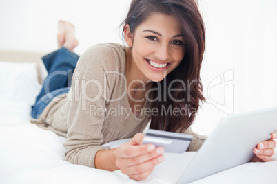 Woman looking straight ahead, with her credit card and tablet in