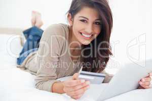 Woman looking straight ahead, with her credit card and tablet in