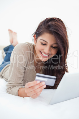 Close up, woman reading credit card infront of tablet