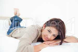 Woman lying on the bed, her hands under her head with her feet c