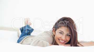 Low angle, woman lying on the bed, smiling with her legs crossed