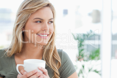 Woman with her head turned to the side and a mug in her hands