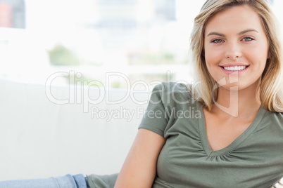 Woman smiling while lying across the couch
