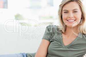 Woman smiling while lying across the couch