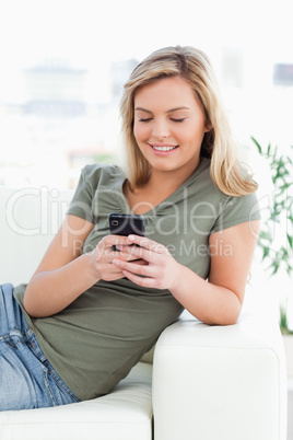 Close up shot of a woman lying on the couch, while using her pho