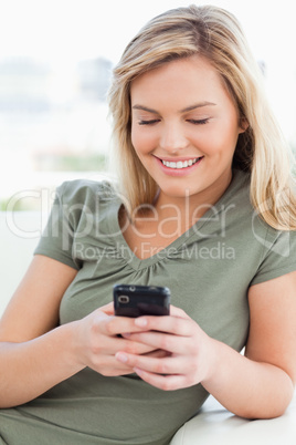 Close up, woman smiling and using her phone