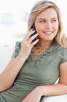 Close up, woman making a call while looking to the side and smil