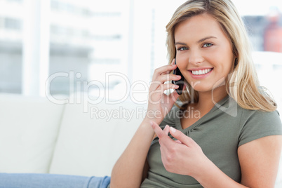 Woman with a raised hand, making a call, smiling and looking for