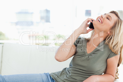 Woman with head raised back and smiling as she makes a call whil
