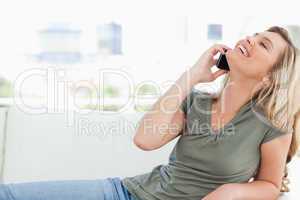 Woman with head raised back and smiling as she makes a call whil