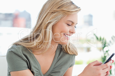 Woman smiling as she uses her phone in her hands