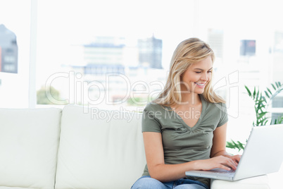 Woman using her laptop on the couch and smiling