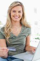 Close up, woman using her credit card and laptop while smiling a
