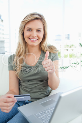 Woman smiling and giving a thumbs up as she looks in front of he