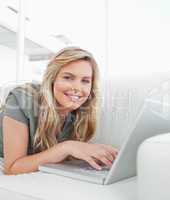 Woman looking forward,using her laptop and smiling
