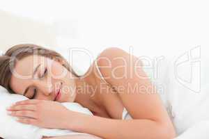 Woman lying in bed asleep smiling softly