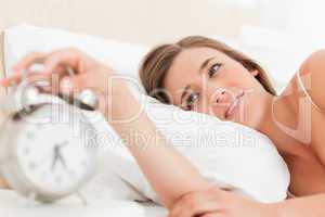 Woman silencing her alarm clock with her hand