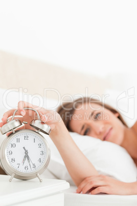 Woman silencing her alarm clock with her hand