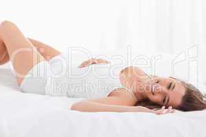 Woman smiling, lying on the bed on her back