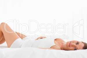 Woman lying on the bed on her back, looking straight ahead