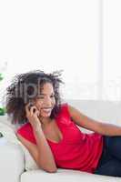 Woman smiling while making a phone call on the couch