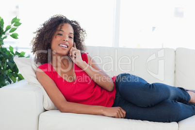 Woman making a call, while smiling and looking forward on the co
