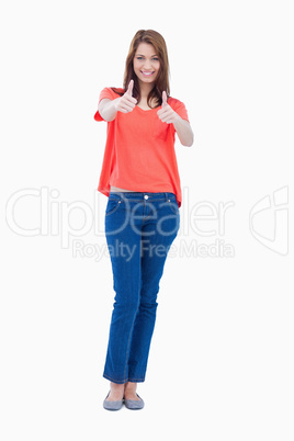 Teenager looking at the camera with her thumbs up