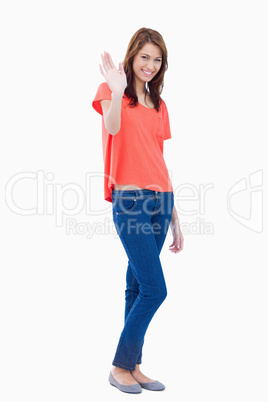 Young woman raising her hand as a greeting