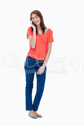 Relaxed teenager smiling while talking on the phone