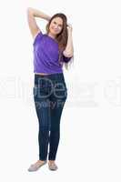 Teenage girl standing up with her arms behind her head