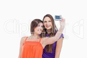 Teenage girl taking a photo of her and her friend