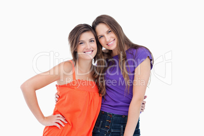 Smiling young women taking each other by the waist