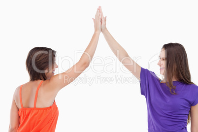 Two friends joining their hands in the air