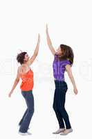 A teenage girl keeping her hand in the air while her best friend