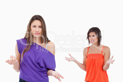 Teenage girl wondering why her friend is angry at her