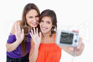 Teenagers waving for a digital camera