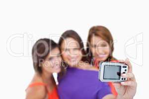 Digital camera photographing three teenagers