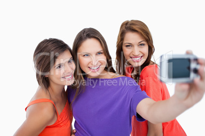 Three beautiful teenagers showing beaming smile in front of the