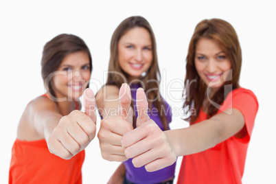 Smiling teenagers showing their approval by putting their thumbs Smiling teenagers showing their approval by putting their thumbs
