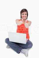 Teenage girl sitting cross-legged and showing her happiness by p