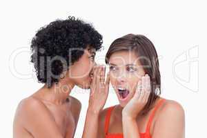 Teenager hearing a surprising secret from her friend