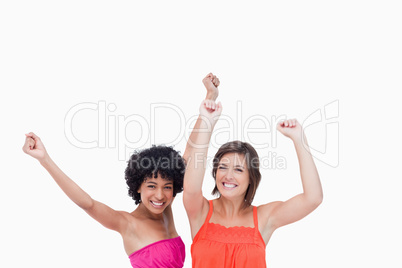 Happy teenagers raising their arms above their head