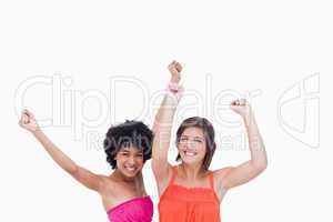 Happy teenagers raising their arms above their head