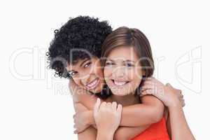 Teenager giving back hug to her friend