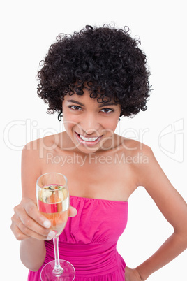 Young woman showing a beaming smile while holding a glass of cha