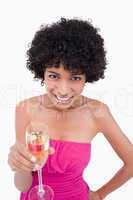 Young woman showing a beaming smile while holding a glass of cha