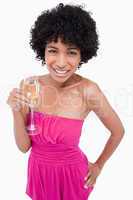 Young woman holding a glass of champagne with her hand on her hi