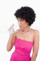 Teenage looking to the side while drinking a glass of water