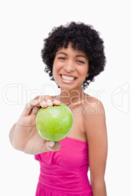 Beautiful green apple held by a young female against a white bac