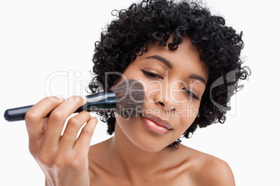 Teenager precisely applying powder with her black brush